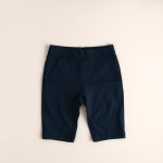 Navy blue high waisted bike shorts with pockets, neatly folded on a neutral surface, top-down flat lay view.