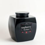 Black cross top with raspberry tea leaves design, studio shot on white background.