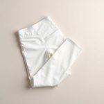 Flat lay of black high waisted leggings with pockets scrunch bum leggings in white, neatly folded on a neutral surface.