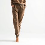 Black jogger pants womens lounge pants pockets in beige, hyperrealistic studio photo on white background.