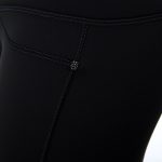 Close-up of seamless black leggings with pockets, highlighting fabric texture and quality stitching.