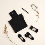 Flat lay of eco brands australia womens boutiques near me top, neatly folded in black on a neutral surface.