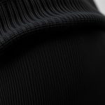 Close-up of Merino Wool fabric and stitching on flare black yoga pants and long sleeve yoga top for women.