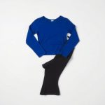 Flat lay of royal blue flare black yoga pants and long sleeve yoga top neatly folded on neutral surface.