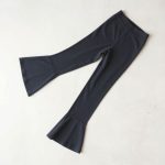 Flat lay of charcoal flare leggings petite flared gym pants neatly folded on a neutral surface.