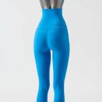 A model wearing high waisted yoga pants in Sky Blue, showcasing the back fit and pockets, on white background.