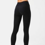 Back view of black leggings with pockets, workout pants with pockets, on a model in a studio with white background.