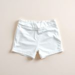Organic cotton yoga shorts in white, folded flat on a neutral surface.