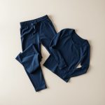 Navy Blue organic cotton yoga pants and matching yoga top with sleeves, neatly folded flat lay.