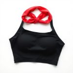 Red yoga crop top and black soft headband on a white background.