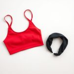A red yoga crop top and black soft headband folded flat on a neutral surface.