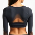 Back view of a charcoal organic cotton yoga crop top on a model, white studio background.
