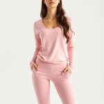 Pastel pink yoga flare pants and long sleeve yoga top for women on white background, hyperrealistic studio photo.