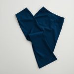 Navy Blue sustainable yoga flared pants folded neatly on a neutral surface.