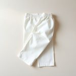 White organic cotton yoga flares folded flat on a neutral surface.