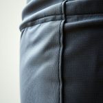Close-up of recycled fabric texture and stitching on yoga pants men male yoga outfit, highlighting quality material.